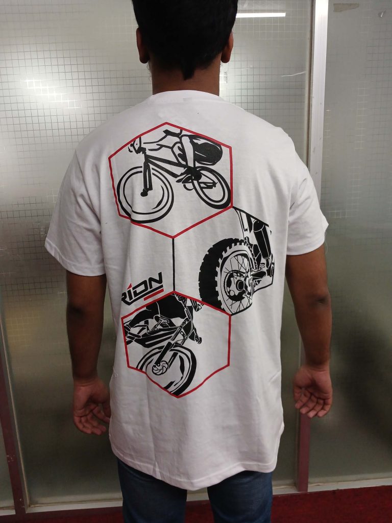 Back view of a black t-shirt featuring a large, bold graphic print for an Australian extreme sports brand, modeled by a young man.